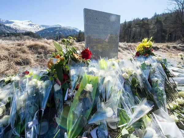Gedenkstele. Nahe der Unglücksstelle haben Angehörige an einer Stele Blumen abgelegt. Auf der Stele steht "In Erinnerung an die Opfer des Flugzeugunglücks vom 24. März 2015" in den vier Sprachen Englisch, Deutsch, Spanisch und Französisch.