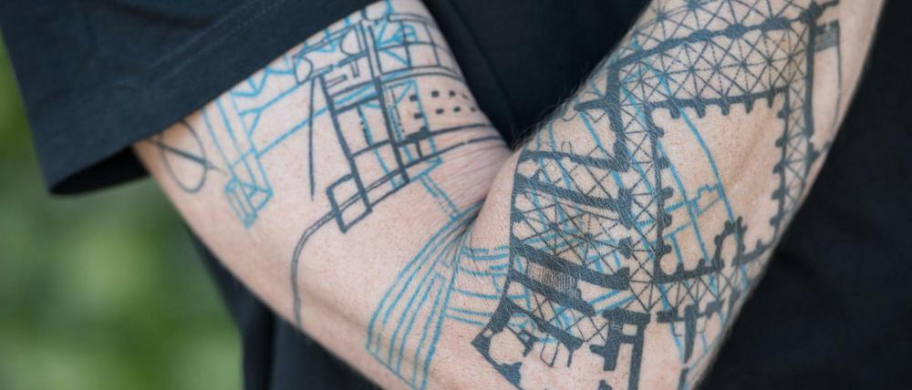 Architekt Joachim Träuptmann präsentiert sein Unterarm-Tattoo. 