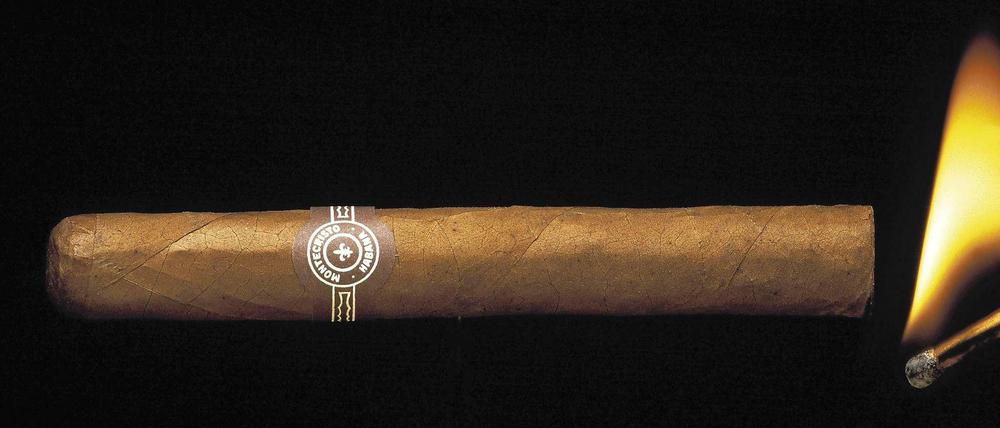 Eine Montecristo-Zigarre wird mit einem Streichholz angezündet.