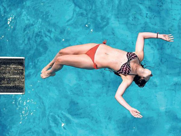 Abkühlung: Ein Mädchen springt im Sommerbad Wilmersdorf vom Drei-Meter-Sprungbrett in das Wasser. 