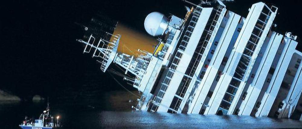 Unbeirrt. Während die Costa Concordia auf dem Felsen liegt, fährt ihr Schwesterschiff Costa Serena hell erleuchtet vorbei. Das Schiff fährt dieselbe Route wie die Costa Concordia und bietet das gleiche Programm. 