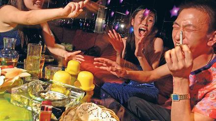 Bild aus dem kommunistischen China. Ein Multimillionär vergnügt sich mit Frauen in einem Nachtclub. 