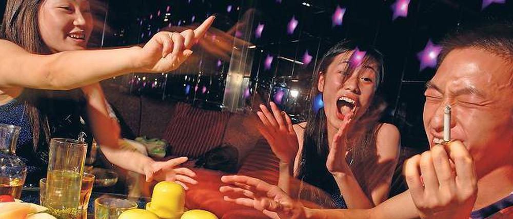 Bild aus dem kommunistischen China. Ein Multimillionär vergnügt sich mit Frauen in einem Nachtclub. 