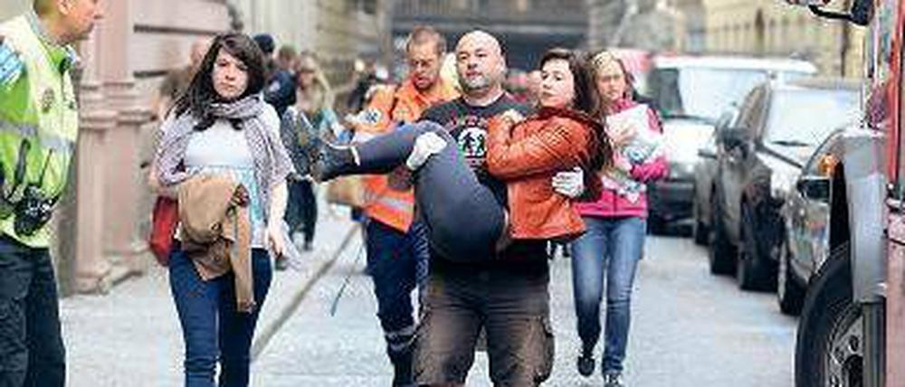 Eine verletzte Studentin wird vom Unglücksort getragen. Foto: AFP