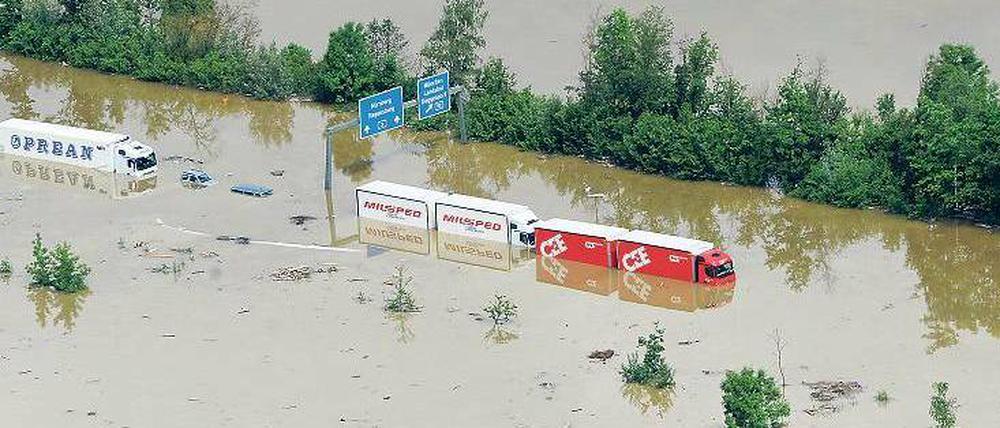 Verlassene Lastwagen stehen auf der Autobahn bei Deggendorf unter Wasser. 