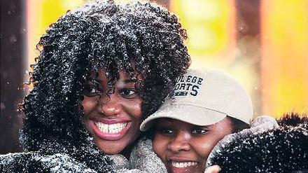 Frauen auf dem Times Square freuen sich über die Schneeflocken.