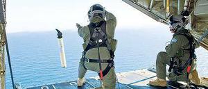 Ein australischer Marineoffizier wirft eine Markierungsboje ins Wasser. 