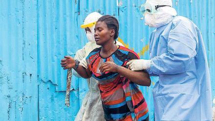 Überforderte Staaten. Klinikmitarbeiter in Monrovia betreuen eine Patientin.