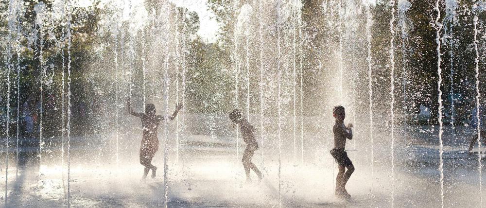 Kinder spielen in einem Brunnen in der griechischen Hauptstadt Athen.