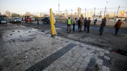 onIrakische Sicherheitskräfte inspizieren den Tatort von einem der Bombenanschläge in Bagdad.