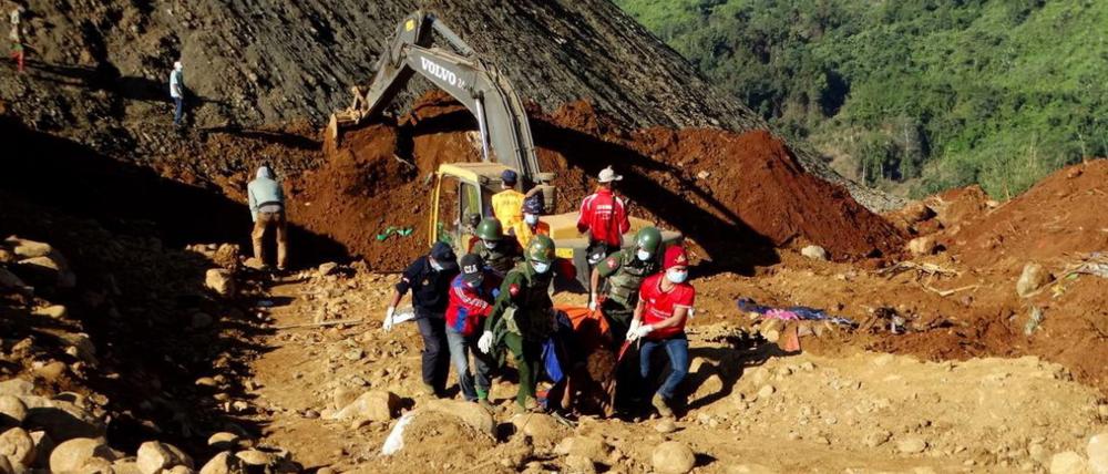 Soldaten und Hilfskräfte in Myanmar ziehen den toten Körper eines Arbeiters aus den Erdmassen. Bei dem Erdrutsch kamen bisher 110 Menschen ums Leben. 