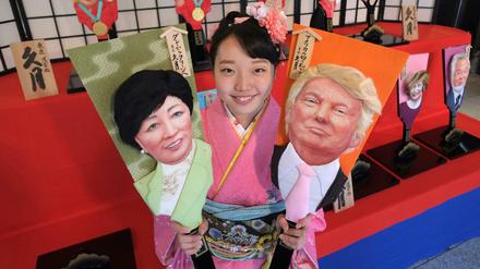 Donald Trump und Tokyos Gouverneurin Yuriko Koike auf japanischen "Glücksbringer-Paddeln". 