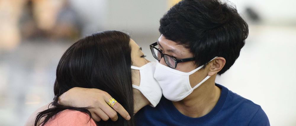 Dieses Pärchen in Busan küsst sich vorerst sicherheitshalber mit Gesichtsmaske. Die Menschen in Südkorea haben Angst vor dem Mers-Virus. Insgesamt sechs Tote und 87 Infektionen sind inzwischen im Land erfasst.