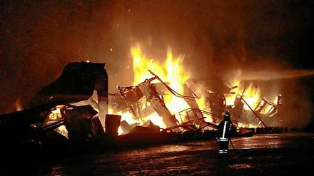 Ein Feuerwehrmann vor der in Flammen stehenden Kamelfarm: In der Nacht zum Donnerstag kamen hier 85 Tiere ums Leben gekommen. 