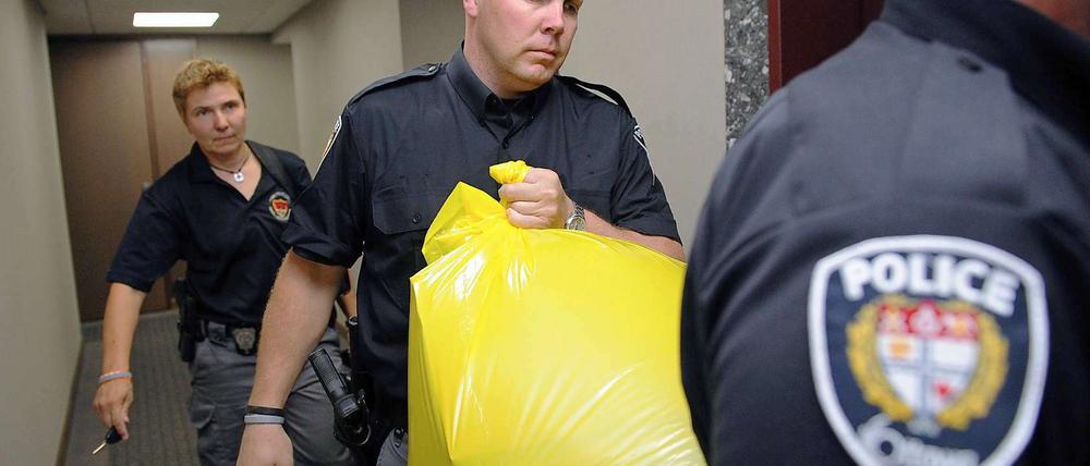 Grausiger Fund. Polizisten tragen das Paket mit dem menschlichen Fuß aus der Zentrale der Konservativen Partei in Ottawa. 