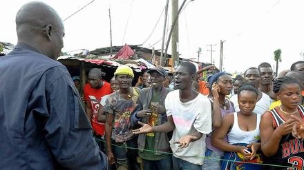Das Armenviertel West Point in der liberianischen Hauptstadt Monrovia ist unter Quarantäne gestellt worden. Die Einwohner sind nun Gefangene in ihrer eigenen Stadt - und fürchten sich umso mehr vor einer Ansteckung mit Ebola. Hier argumentieren sie mit einem Sicherheitsbeamten, der sie daran hindern soll, den Stadtteil zu verlassen. 