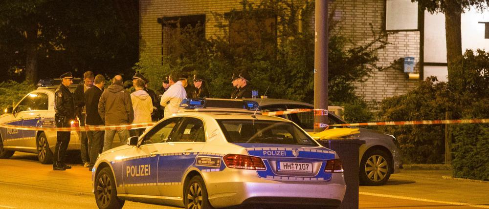 Polizeikräfte stehen am frühen Mittwoch in Hamburg vor einem Wohnhaus. Ein Hausbewohner soll am Abend einen mutmaßlichen Einbrecher erschossen haben.