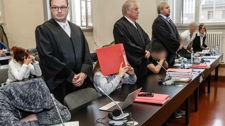 Die Angeklagten sitzen in Hamburg zwischen ihren Verteidigern auf der Anklagebank.
