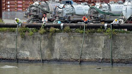 Einsatzkräfte versuchen, Öl aus dem Fluss Polcevera abzupumpen.