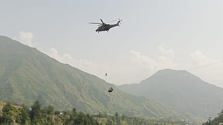 Ein Armeesoldat seilt sich von einem Hubschrauber ab, um Schüler zu bergen, die in einem Sessellift festsitzen.