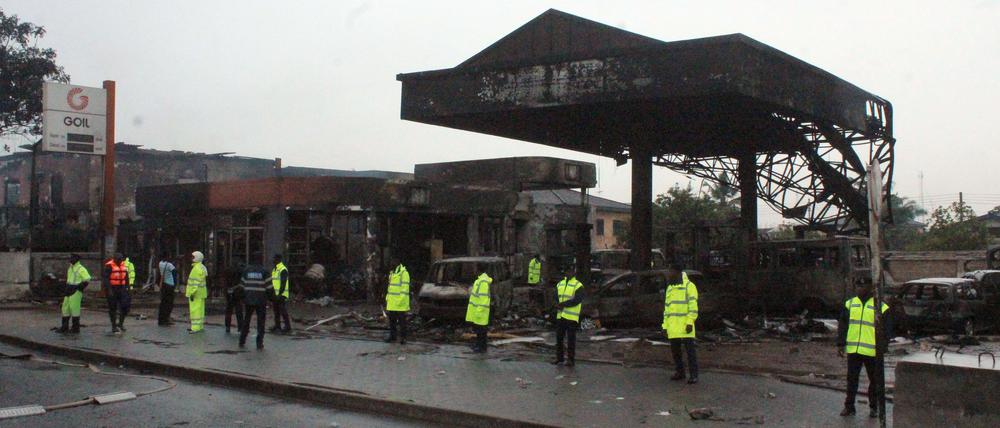 Polizisten und Rettungskräfte vor der abgebrannten Tankstelle in Accra. Bei einer Explosion in Ghana sind 150 Menschen ums Leben gekommen. 