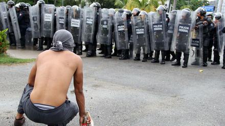 Ein Demonstrant stellt sich im mexikanischen Acapulco bewaffnet Polizisten entgegen.