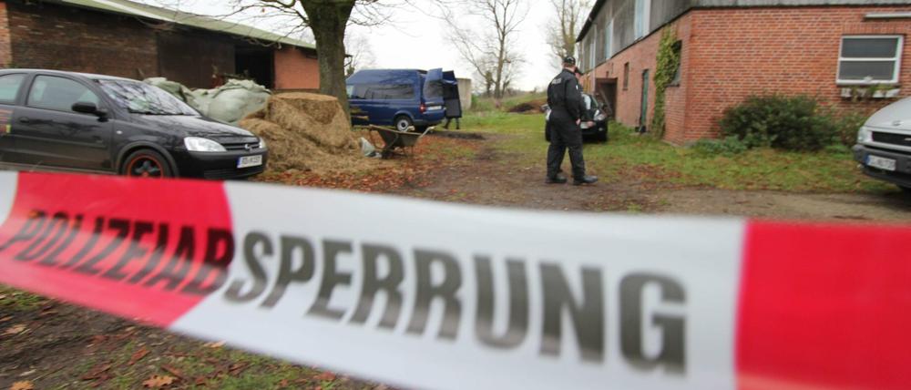 Spezialisten der Polizei untersuchen am 19.11.2014 hinter einer Polizeiabsperrung im Dorf Haale (Schleswig-Holstein) einen Brandort.