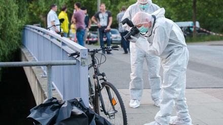 Ein Ermittler der Polizei fotografiert am Sonntag in Hamburg-Bergedorf in der Nähe des Allermöher Badesees am Tatort ein Fahrrad. 