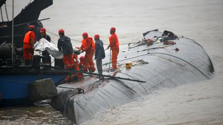 Rettungsteams bergen eine Leiche aus dem Schiff, das auf den Jangtse-Fluss in China am Montag gekentert ist. 
