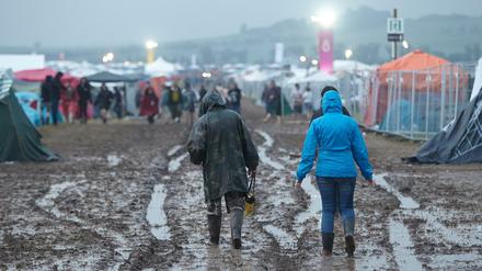 "Rock am Ring": Festivalbesucher gehen nach einem Gewitterregen über das aufgeweichte Gelände.