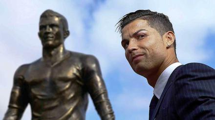 Der Weltfußballer 2015 Christiano Ronaldo vor einer Statue auf Madeira (Portugal) , die ihn selbst zeigt.