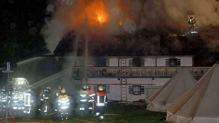 Einsatzkräfte der Feuerwehr kämpfen in Schneizlreuth gegen die Flammen in einem Eventhotel.