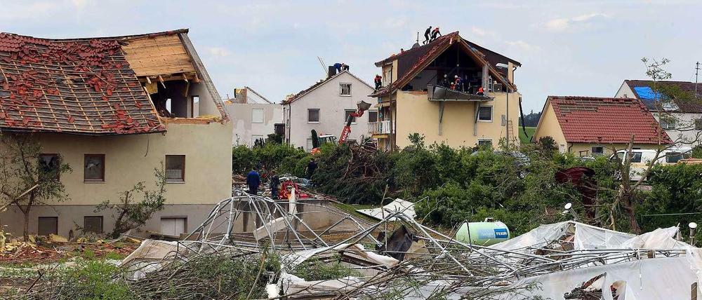 Helfer arbeiten am Donnerstag in Gebenhofen, einem Ortsteil der Gemeinde Affing im Landkreis Aichach Friedberg (Bayern), an beschädigten Wohnhäusern.