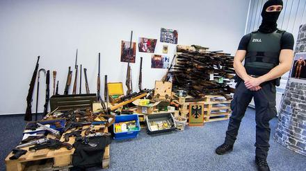 Ein Zollbeamter vor einem Waffenarsenal in einem Haus in Schwerte. Ein 54-Jähriger betrieb unerlaubten Handel. 