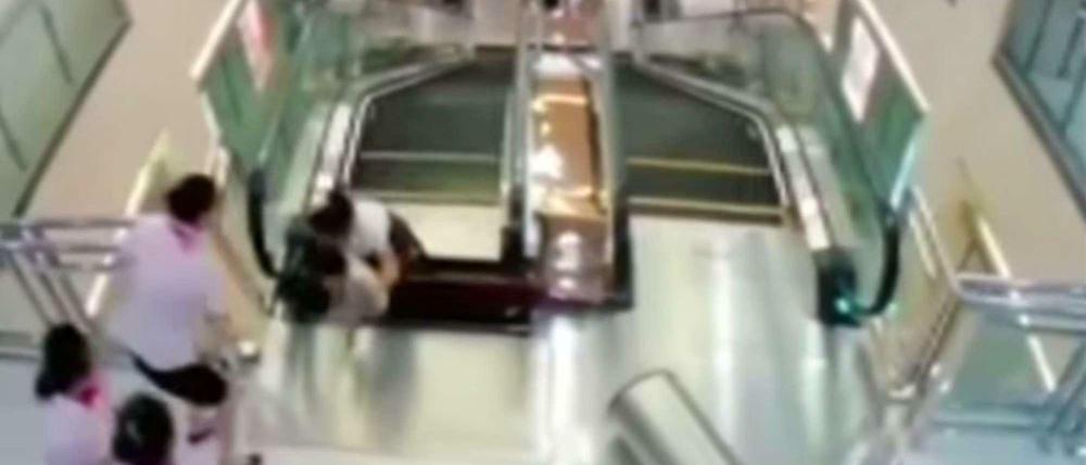 Eine Frau in China rettet ihrem Kind an der Rolltreppe das Leben und wird dann selbst von dieser verschluckt. 