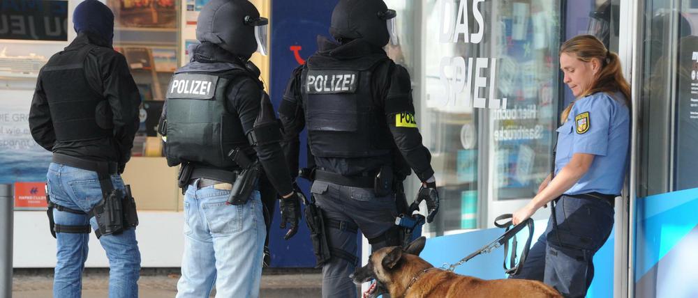 Einsatzkräfte der Polizei warten am 07.08.2016 in der Nähe des Rathauses in Saarbrücken (Saarland) auf ihren Einsatz. In der Innenstadt hat sich der Polizei zufolge ein Bewaffneter in einem Lokal verschanzt. Foto: Becker&amp;Bredel/dpa +++(c) dpa - Bildfunk+++