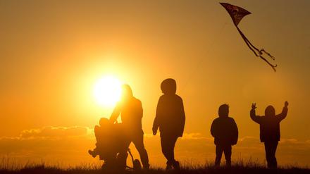 Eine Familie genießt den Sonnenuntergang an der Nordsee.