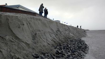 Strand weg: Passanten stehen am 29.10.2017 auf Wangerooge an der Abbruchkante des Strandes. Durch eine Sturmflut des Sturmtiefs «Herwart» und eine wurde ein Teil der Promenade ins Meer gespült.