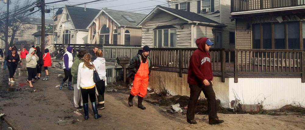 Bewohner von Breezy Point im New Yorker Stadtteil Queens schauen sich die durch "Sandy" angerichteten Schäden an. Bis zu 100 Häuser wurden in Queens durch ein Großfeuer zerstört.