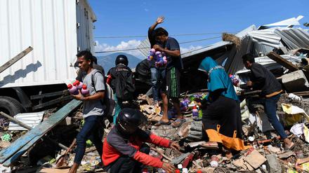 Menschen sichern noch nutzbare Dinge aus den Trümmern eines Hauses im indonesischen Palu.