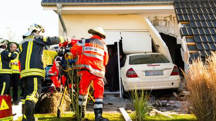 Ein Auto steckt am Montag in Oststeinbek (Schleswig-Holstein) nach einem Unfall in einem Reihenhaus. Der Fahrer hatte mit seinem Wagen die Hauswand durchbrochen und war teilweise in das Gebäude gefahren. Der Mann wurde verletzt.