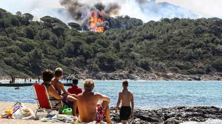 Urlauber an einem Strand nahe Saint-Tropez beobachten die Waldbrände.