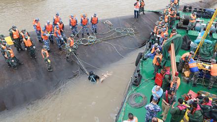 Rettungskräfte bei der Bergung einer Leiche aus dem gekenterten Touristenschiff im Jangtse-Fluss in China am Mittwoch. 