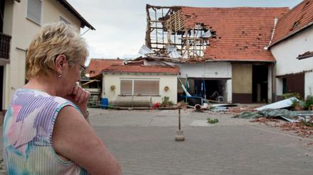 Völlig zerstört ist eine Scheune in Framersheim (Rheinland-Pfalz) nach einem Tornado am Dienstag vor der die Besitzerin steht. Innerhalb von Sekunden hatte die Windhose am Abend mehrere Häuser zerstört und Autos beschädigt. Der Ort wurde abgeriegelt.