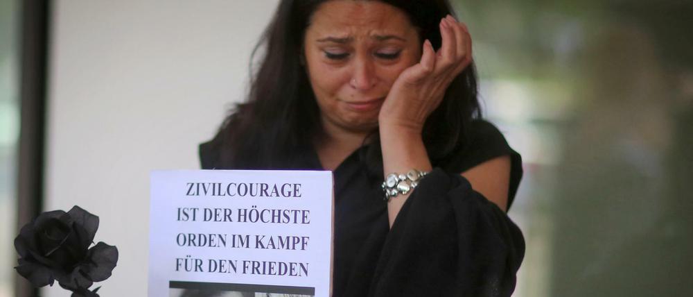 Angehörige und Freunde von Tugce trauern am Dienstag vor dem Landgericht in Darmstadt (Hessen) nach der Urteilsverkündung und halten Bilder von ihr. Das Gericht verurteilte ihn wegen des gewaltsamen Todes der Studentin Tugce A. zu drei Jahren Haft.