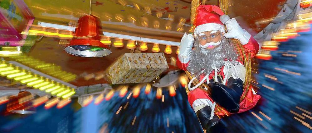 Ein Plastiknikolaus fährt auf dem Berliner Weihnachtsmarkt Karussell.