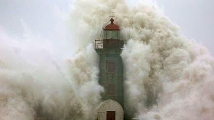 Eine Welle schlägt gegen den Leuchtturm von Porto, Portugal.