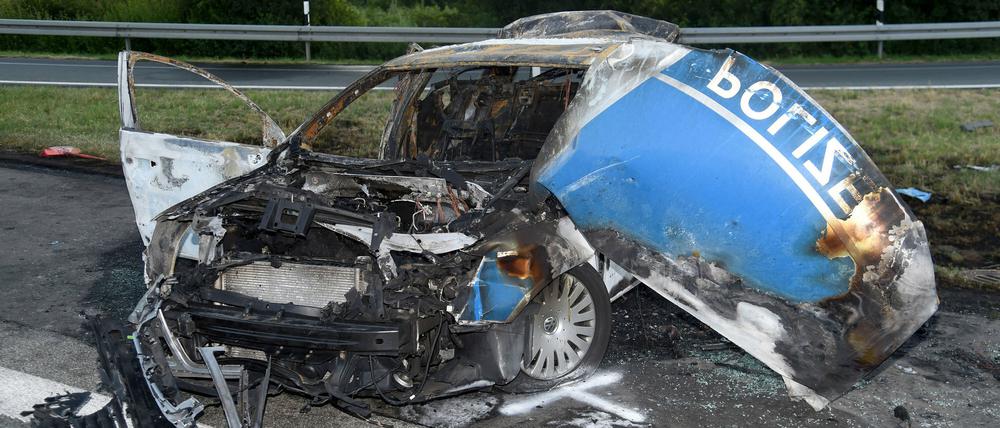 Ein ausgebrannter Streifenwagen der Polizei steht am Donnerstag auf der Autobahn 44 bei Lichtenau (Kreis Paderborn). Zwei Polizisten sind bei dem Unfall ums Leben gekommen.