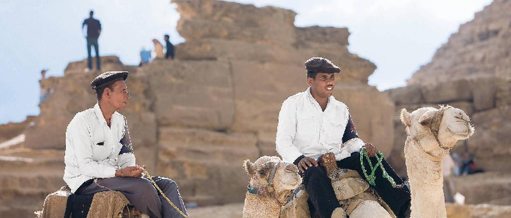 Unter Polizeischutz. An den großen Sehenswürdigkeiten der Welt – hier die Pyramiden von Gizeh – werden die Touristen bewacht. So gut es geht. Foto: laif