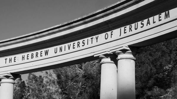JERUSALEM, ISRAEL - FEBRUARY 19, 2014: The Hebrew University of Jerusalem sign on the arch of the amphitheater at Mount Scopus (Har Ha-Tzofim) campus. Mount Scopus campus was inaugurated in 1925. Black and white photo.
